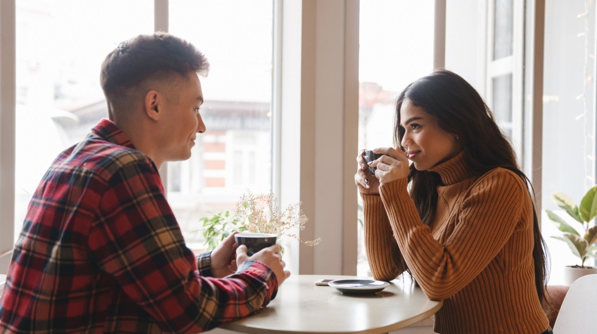 Mann und Frau in einem Café auf einem Date, die sich anlächeln