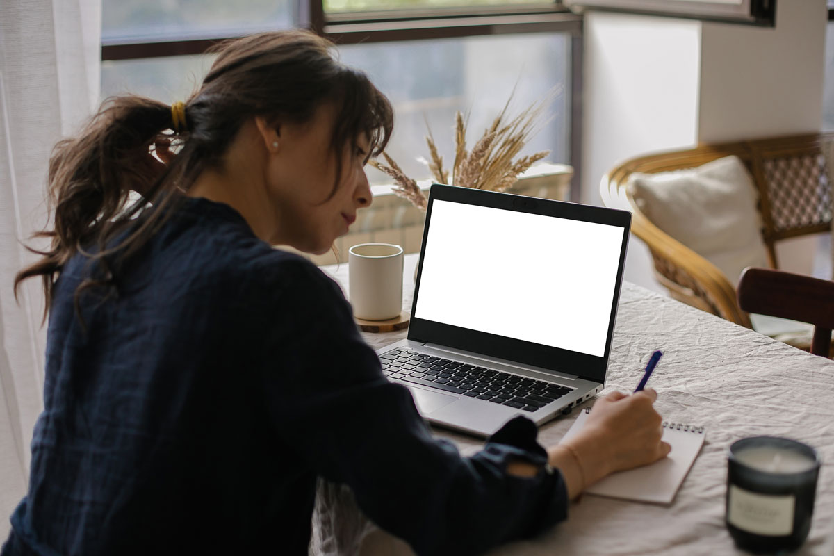 Frau sitzt am Schreibtisch vor ihrem Computer