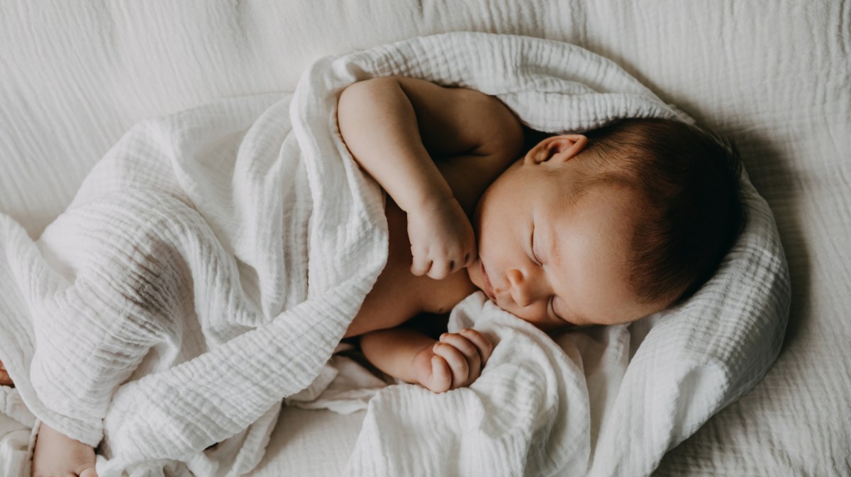 Baby eingewickelt in Decke am Schlafen