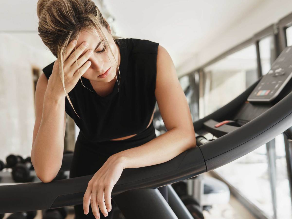 Erschöpfte Frau nach ihrem Fitnesstraining im Fitnessstudio