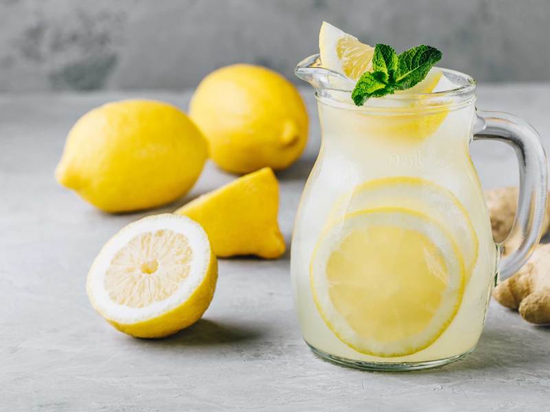 Hausgemachte erfrischende Sommerlimonade mit Zitronenscheiben, Ingwer und Eis