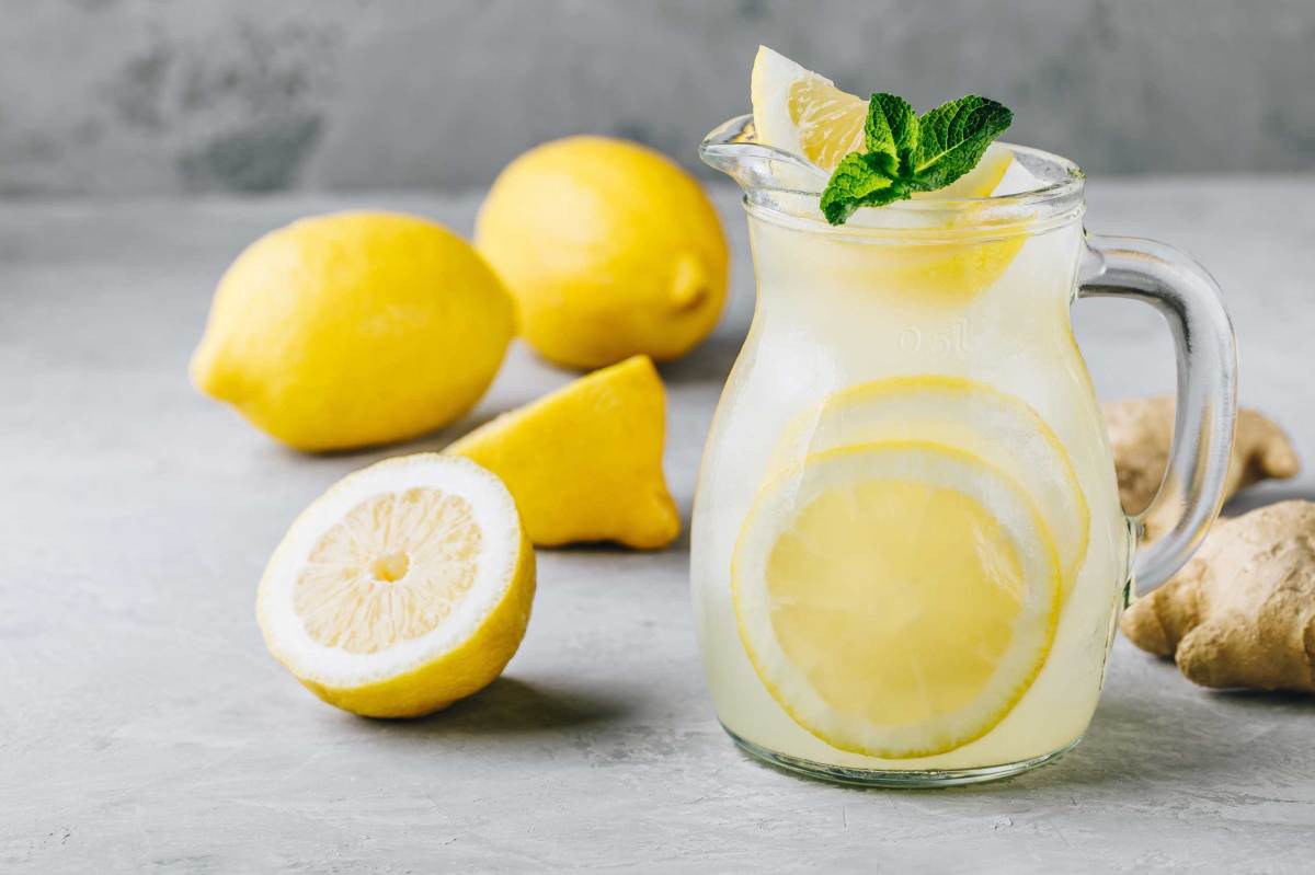 Hausgemachte erfrischende Sommerlimonade mit Zitronenscheiben, Ingwer und Eis