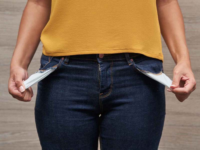 Frau mit Jeans und Gelbem Shirt hat leere Hosentaschen.