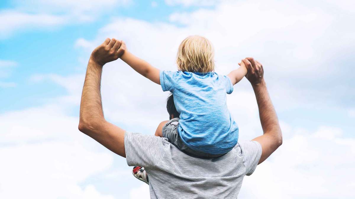 Vater trägt Sohn auf den Schultern.