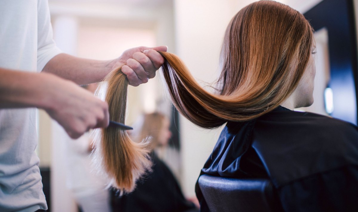 Frau mit sehr langem Haar beim Frisör