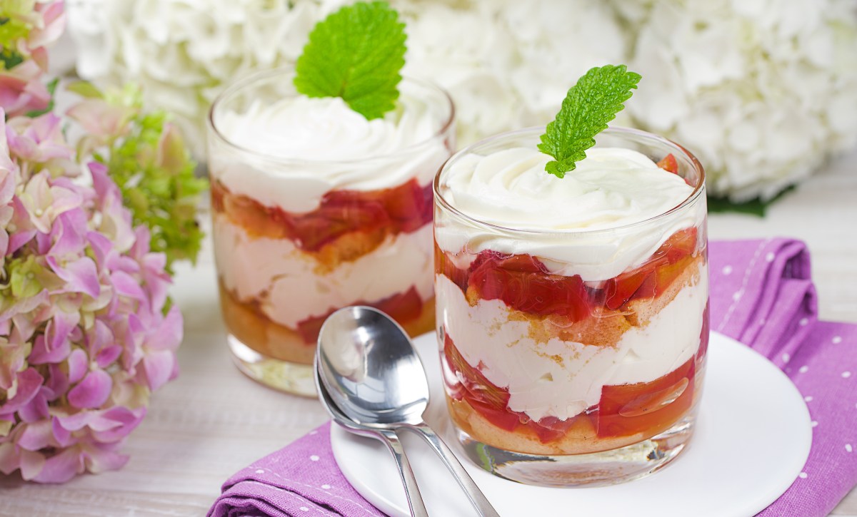 Zwei Dessertgläser mit Rhabarber Tiramisu daneben Hortensien in Lila als Deko