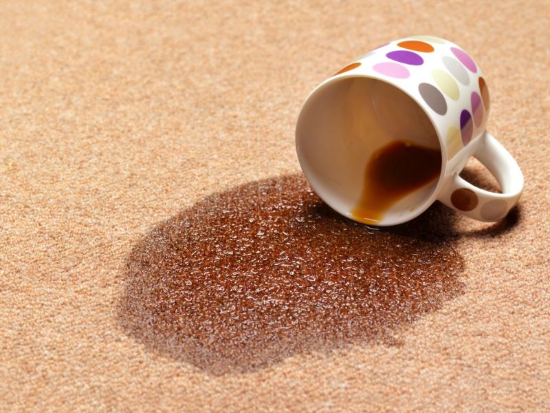 Eine umgekippte Tasse Kaffee auf dem Teppich