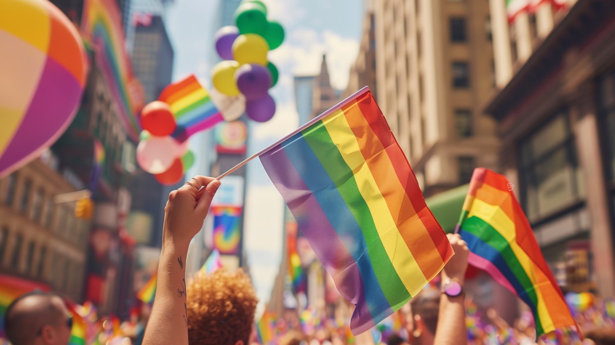 CSD Straßenfest mit Regenbogenflaggen durch eine Stadt.