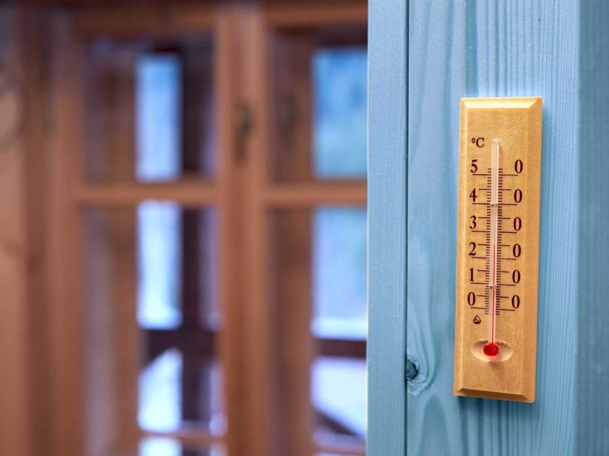Thermometer an Wand neben Fenster zeigt mehr als 25 Grad Celsius