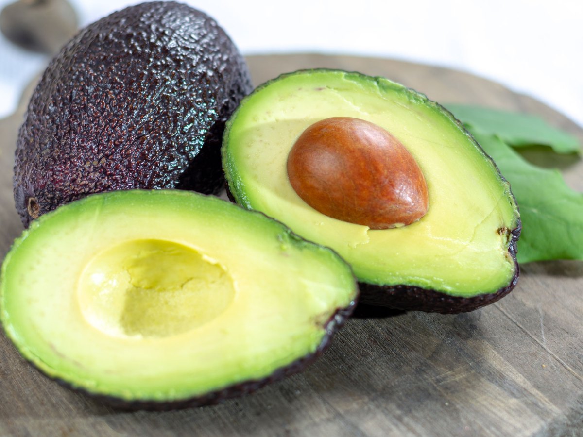 Avocado aufgeschnitten auf Holzbrett