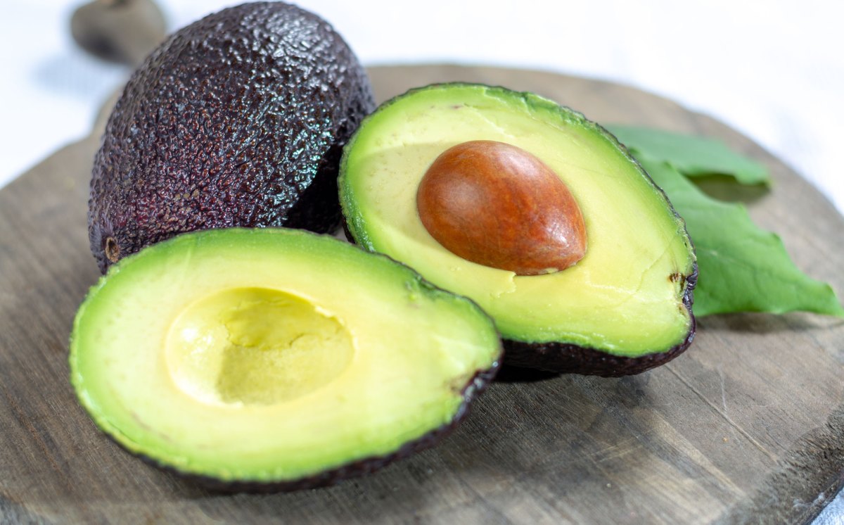 Avocado aufgeschnitten auf Holzbrett