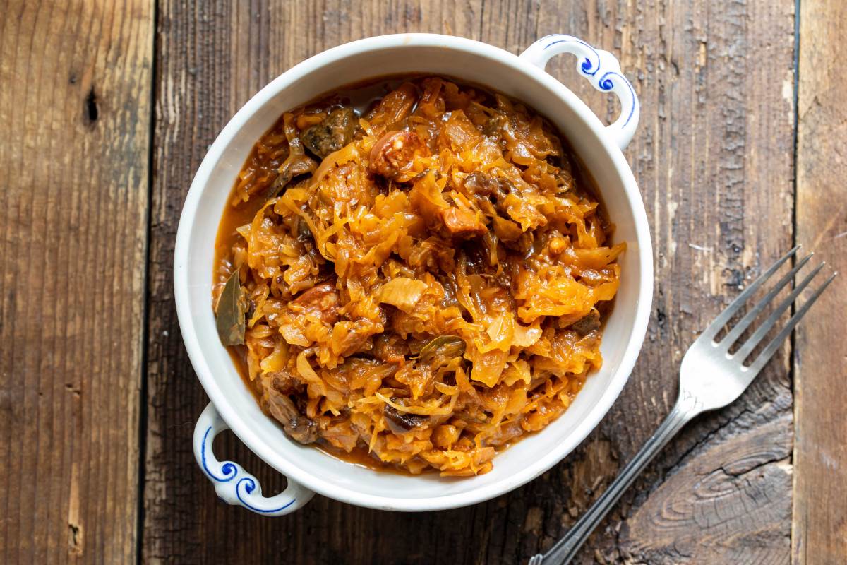 Aufnahme von oben: Schüssel mit einer Portion Bigos, daneben liegt eine Gabel.