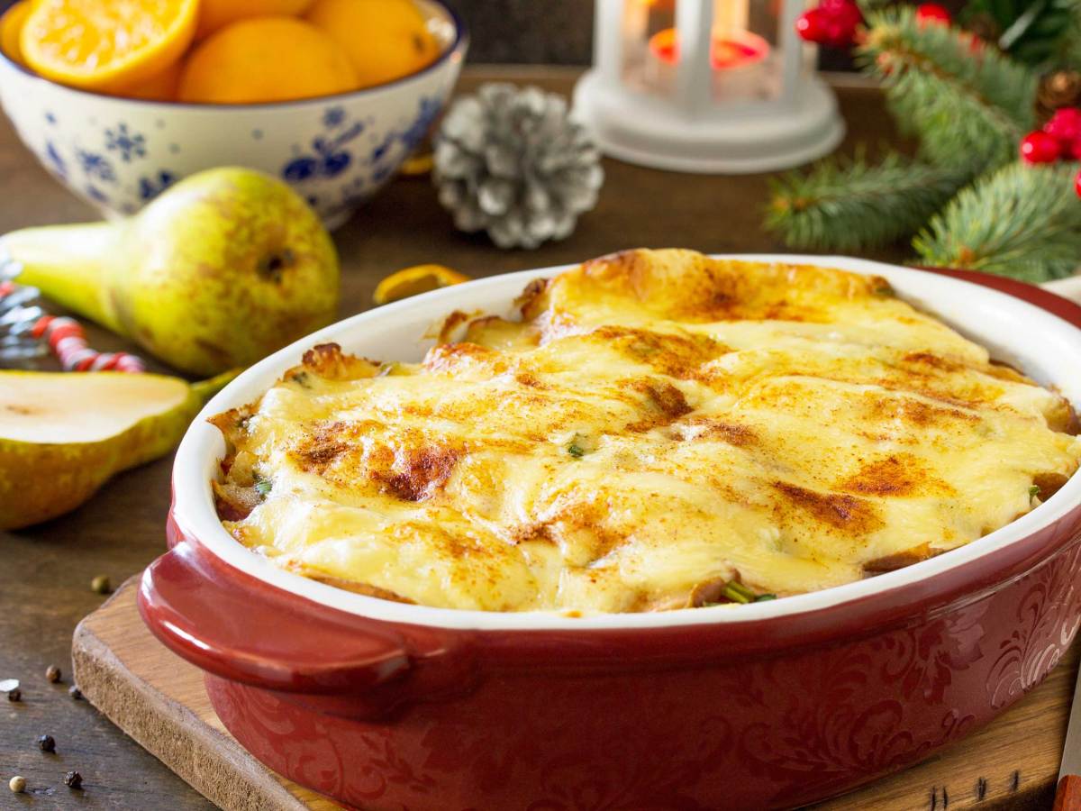 Kartoffelgratin mit Birne, Raclette-Käse und Speck auf einer festlichen Weihnachtstafel