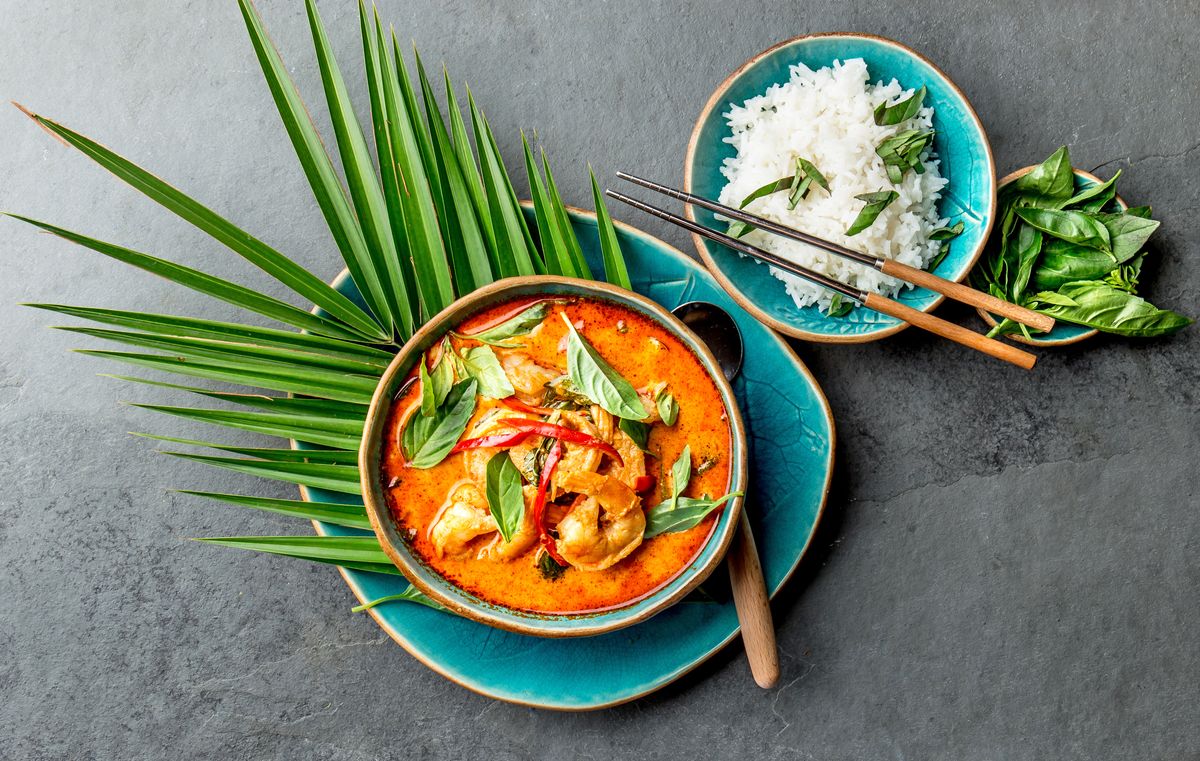 Leckeres thailändisches Gericht mit Reis auf grauem Tisch