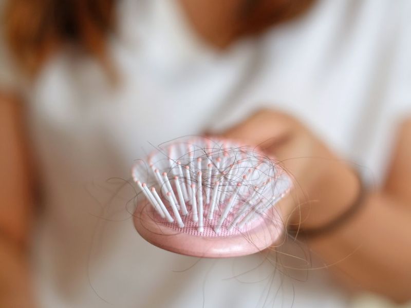 Eine Frau hält eine Haarbürste in der Hand