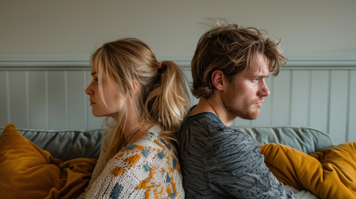 Mann und Frau, Rücken an Rücken, die traurig nach vorne blicken.