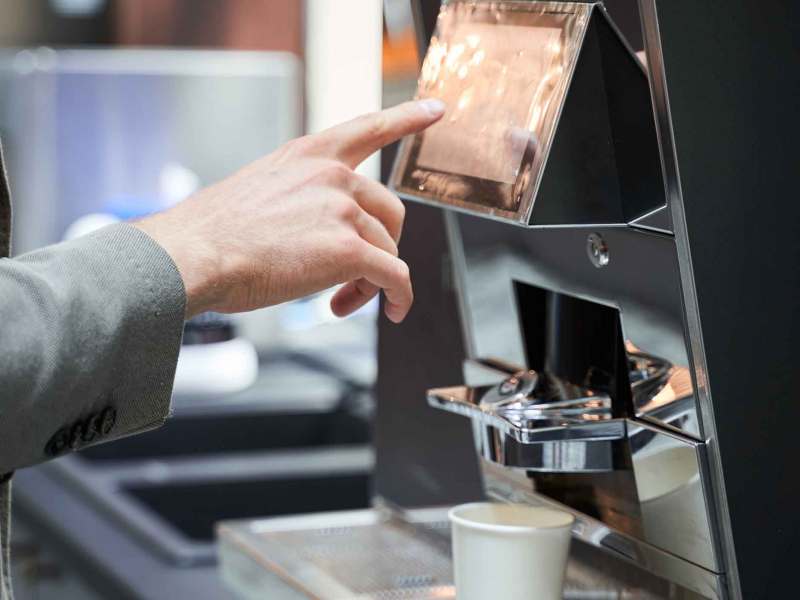 Mann macht sich auf der Arbeit einen Kaffee.