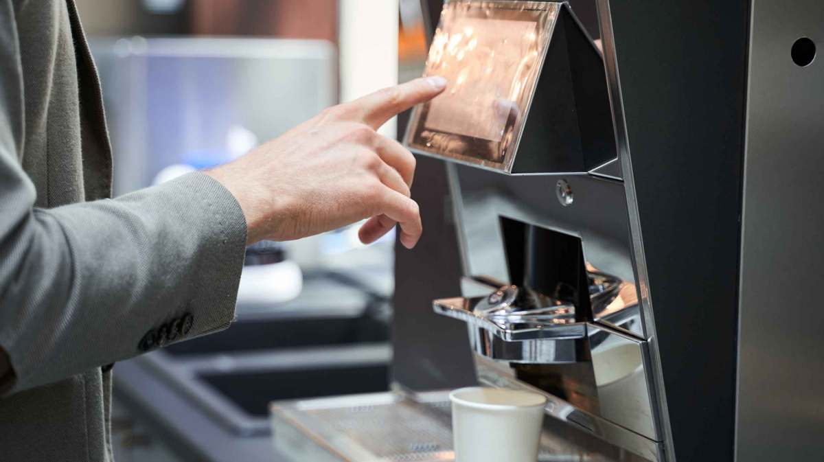 Mann macht sich auf der Arbeit einen Kaffee.