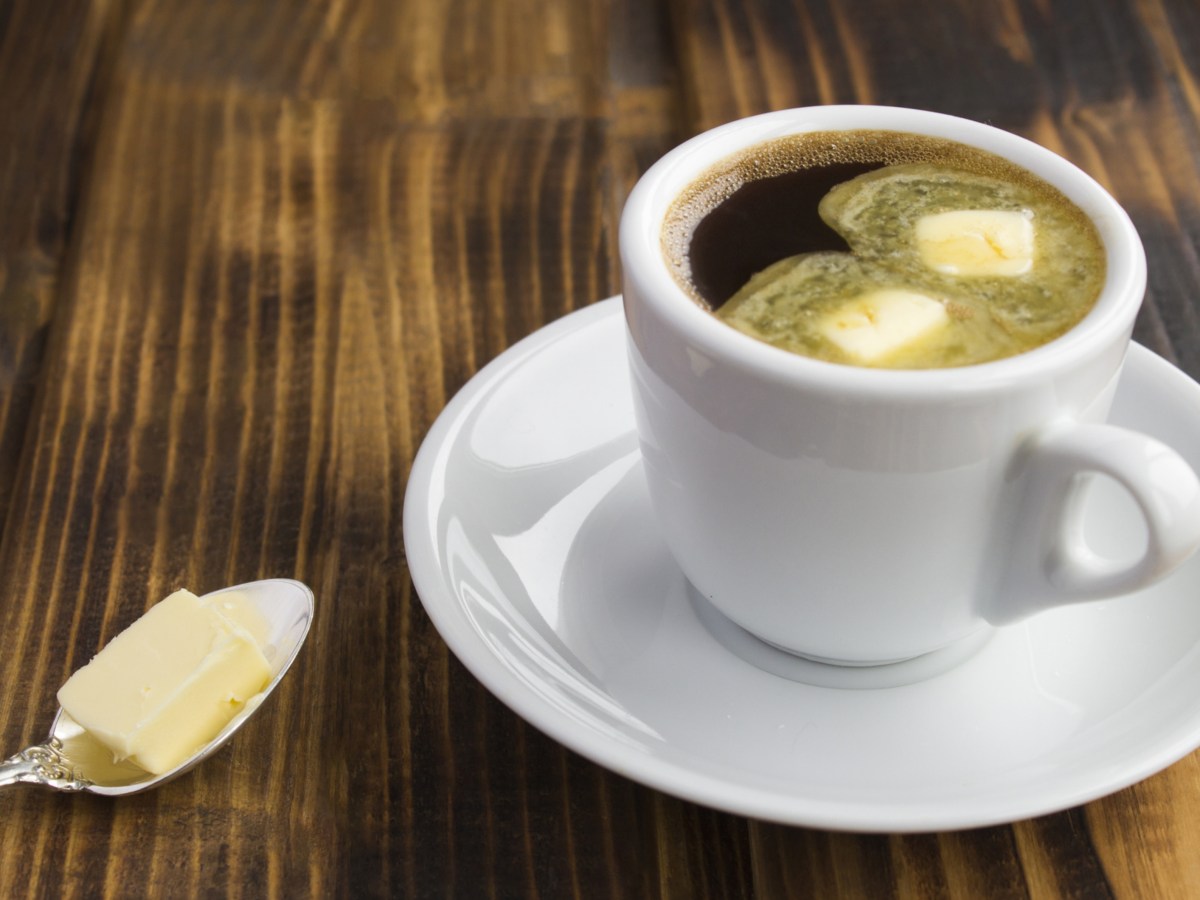 Kaffeetasse auf dem Tisch, Löffel mit Butter daneben