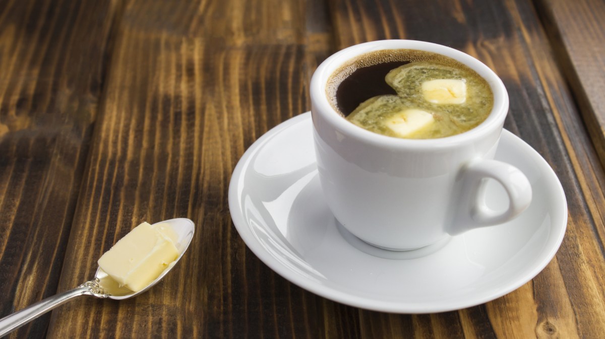 Kaffeetasse auf dem Tisch, Löffel mit Butter daneben