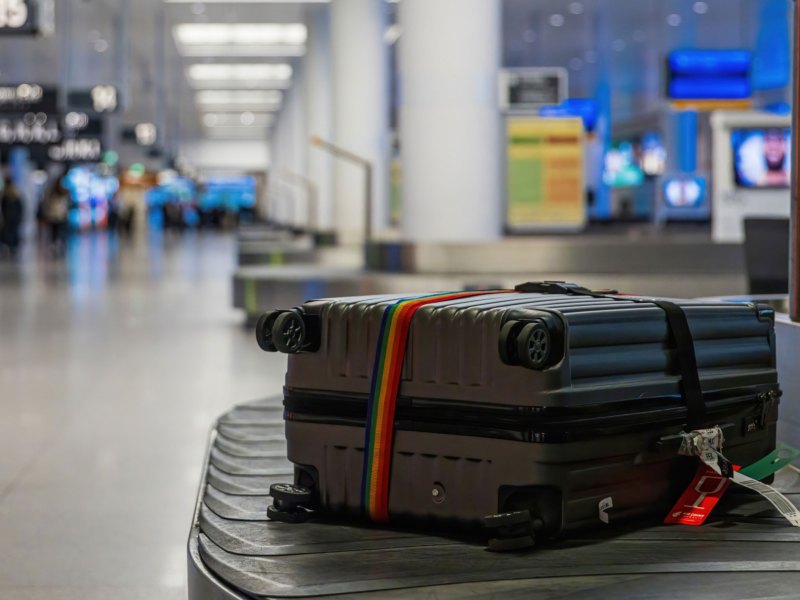 Grauer Koffer auf Gepäckband am Flughafen