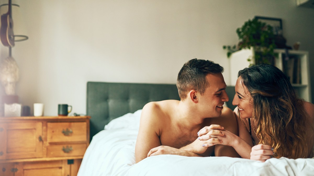 Paar im Bett, das sich gegenseitig anlächelt