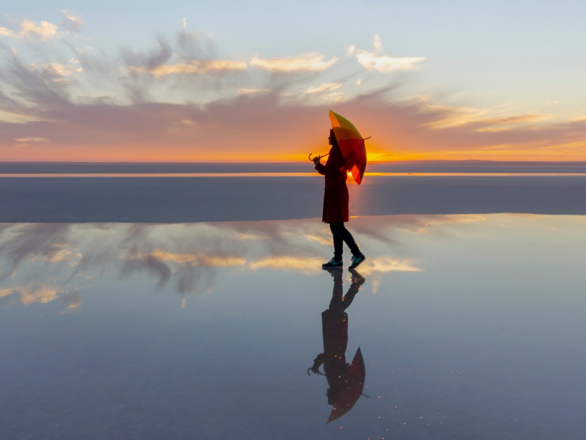 Frau mit Schirm am Strand