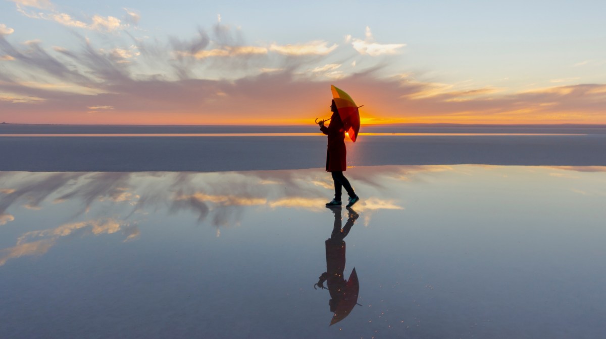 Frau mit Schirm am Strand