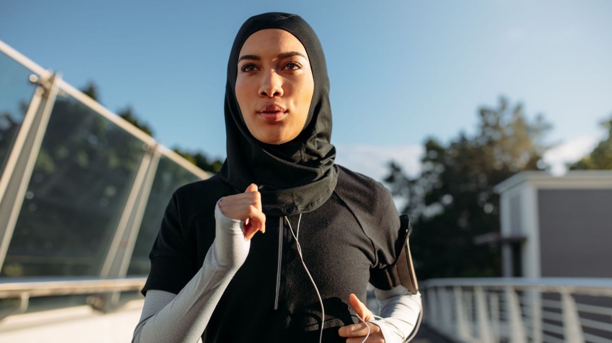 Gesunde sportliche Frau trägt Hidschab beim Joggen