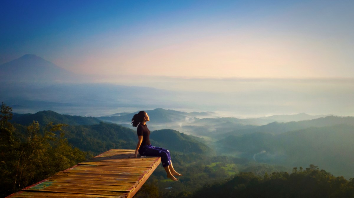 Frau auf Steg vor Landschaft