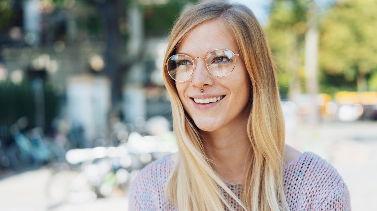 Frau mit Brille lächelt.