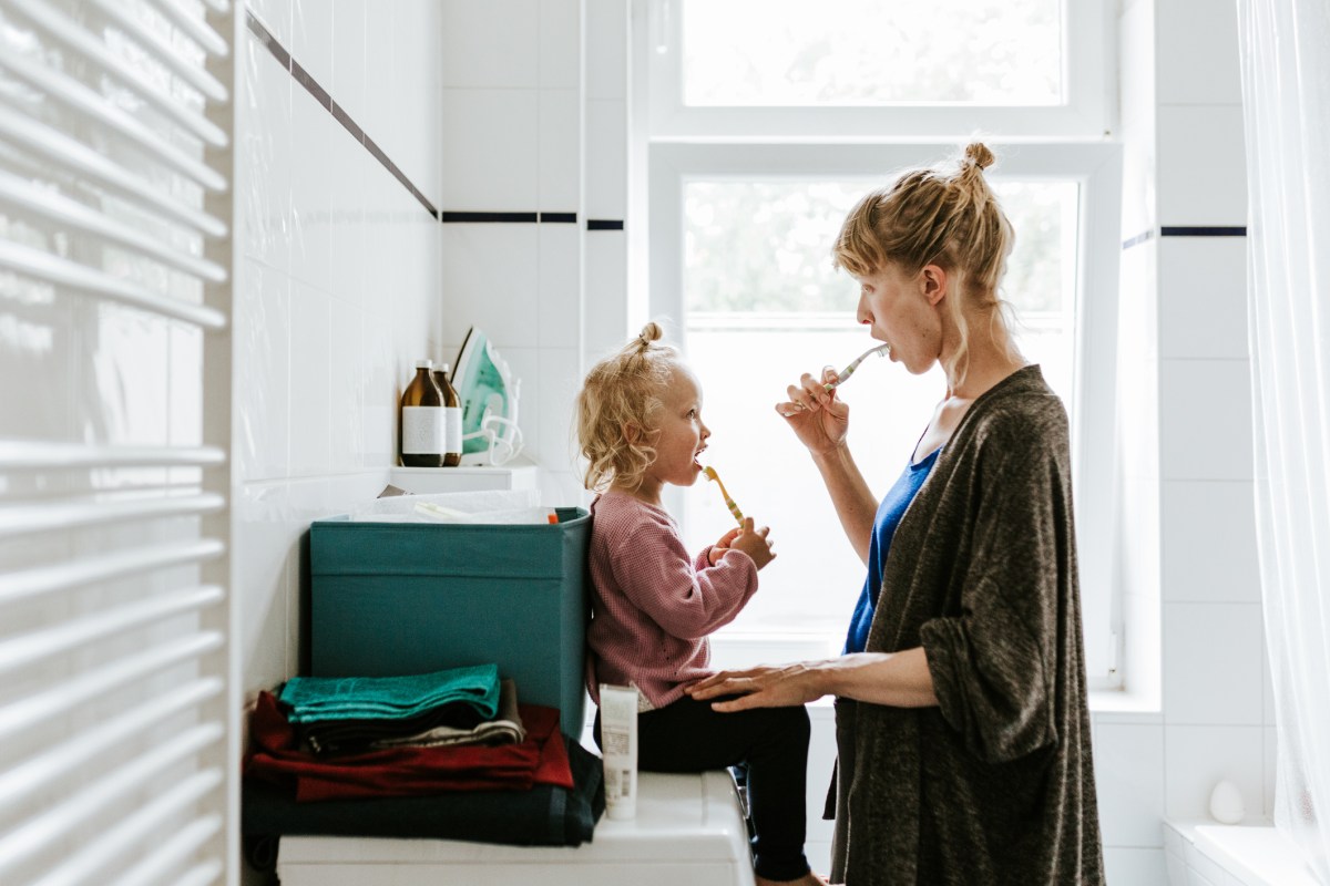 Mutter und kleine Tochter im Bad beim Zähneputzen