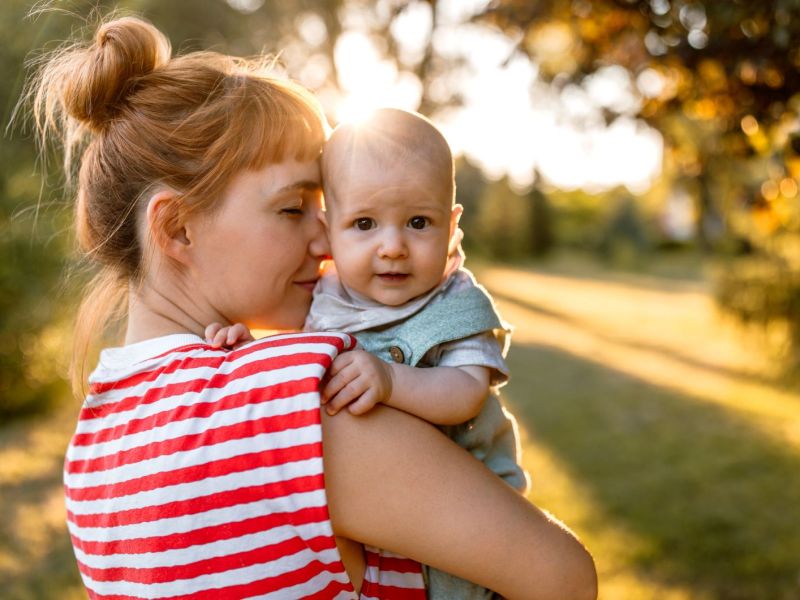 Mutter mit Baby auf dem Arm in der Natur