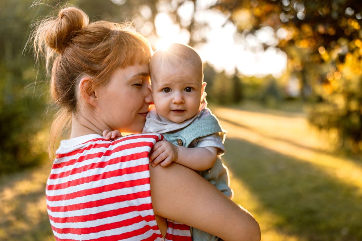 Mutter mit Baby auf dem Arm in der Natur