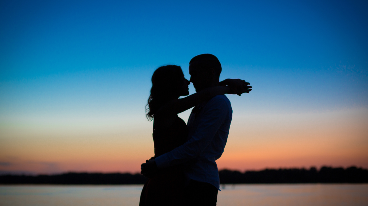 Die Silhouette eines Pärchens beim Sonnenuntergang.