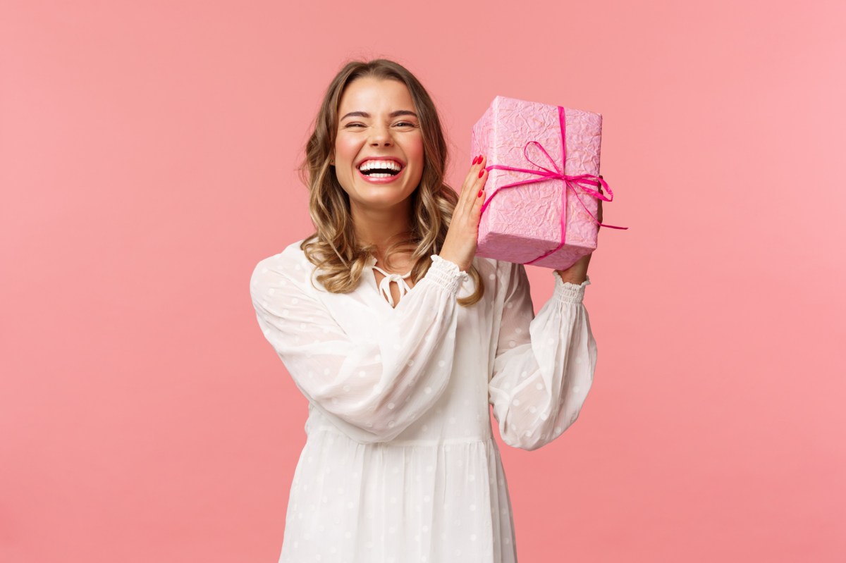 Frau hält ein Weihnachtsgeschenk in der Hand