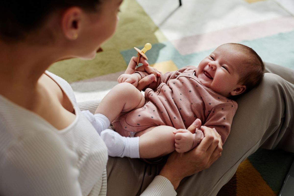 Lachendes Baby auf dem Schoß der Mutter