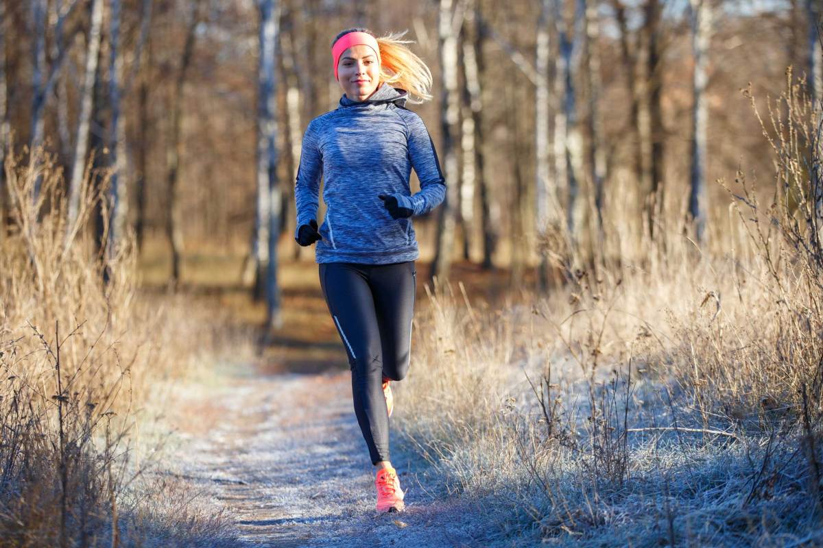 Junge, athletische Frau läuft im Park im Spätherbst oder frühen Winter