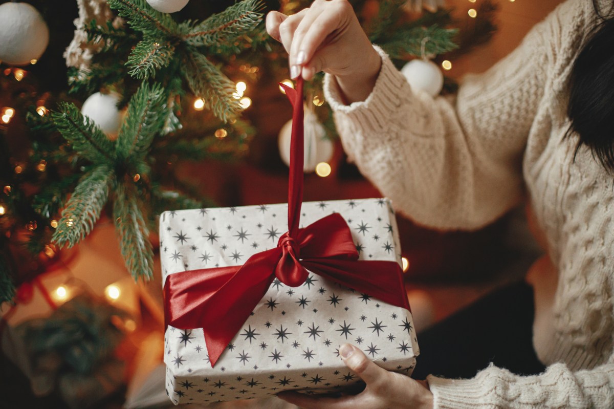 Eine Frau packt ein Weihnachtsgeschenk aus