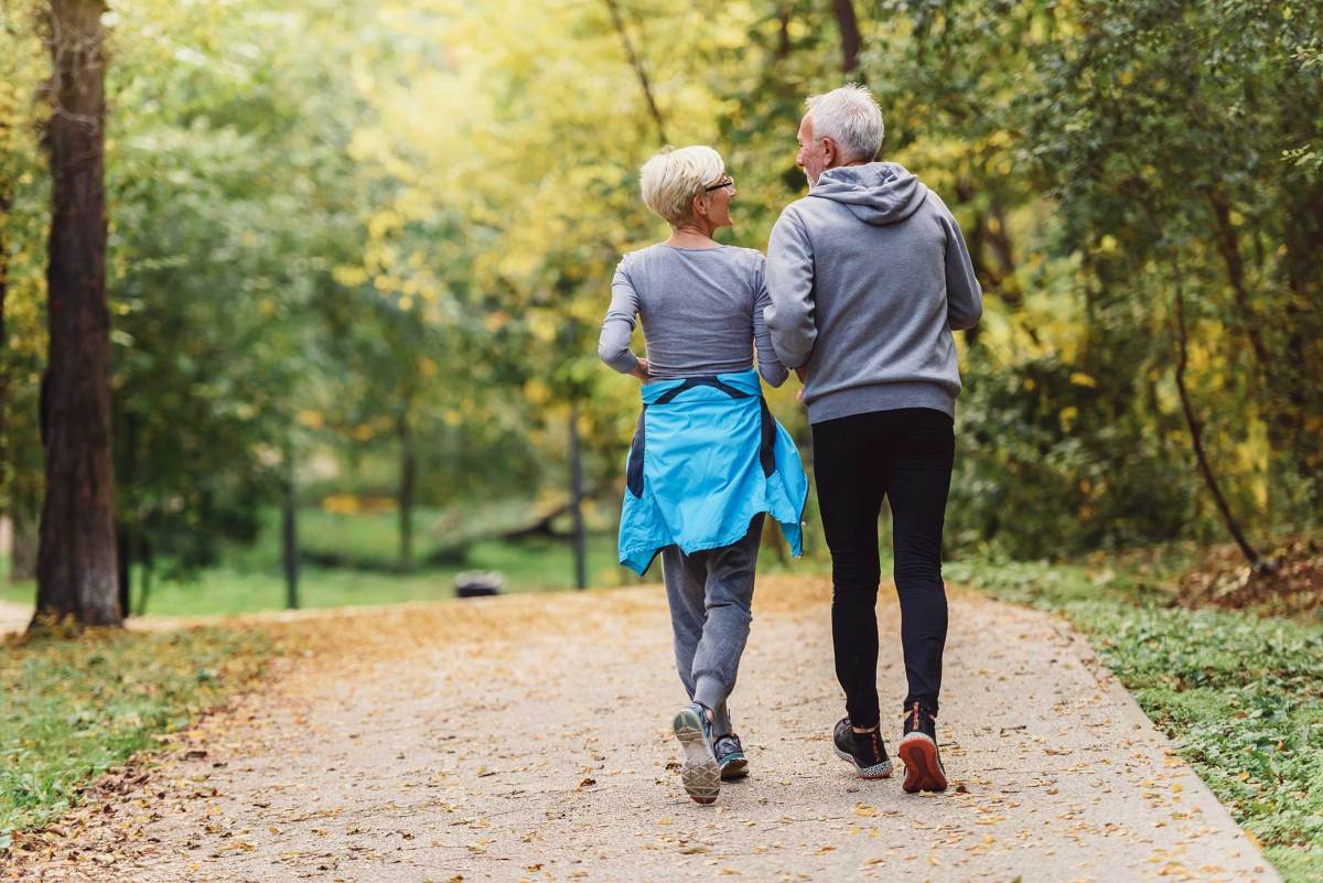 Fröhliches aktives Seniorenpaar beim Joggen im Park. Gemeinsam trainieren, um das Altern aufzuhalten.