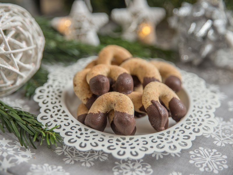 Nussige Kipferl mit Schokoladenüberzug und weihnachtlicher Deko.