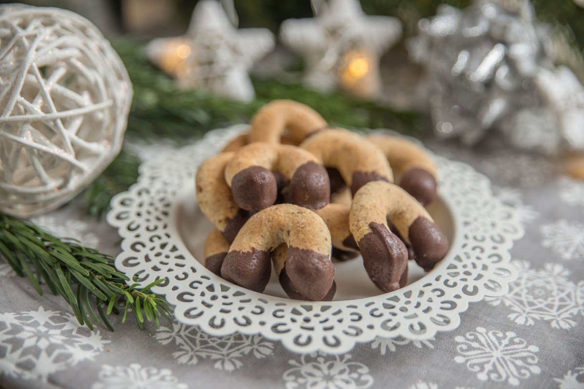 Nussige Kipferl mit Schokoladenüberzug und weihnachtlicher Deko.