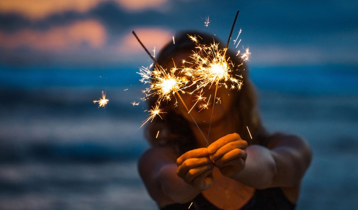 Frau mit Wunderkerzen am Strand