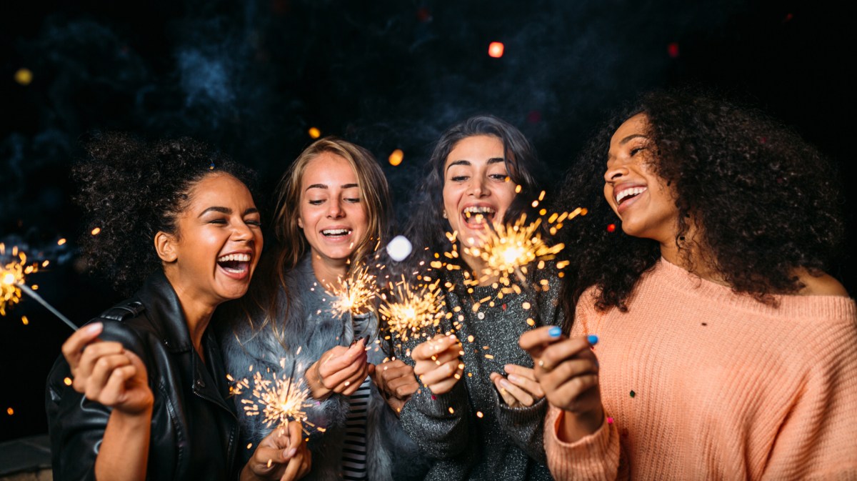 Vier junge Frauen haben Wunderkerzen angezündet.