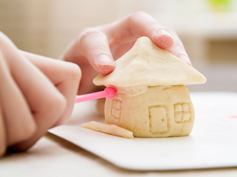 Salzteig-Rezept: Kinderhand formt Häuschen aus Salzteig