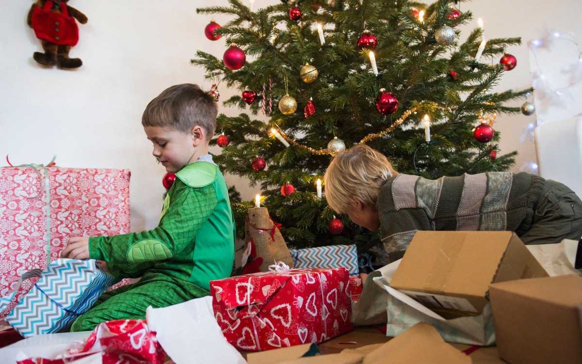 Weihnachtsgeschenke und zwei jüngere Jungen vor Weihnachtsbaum