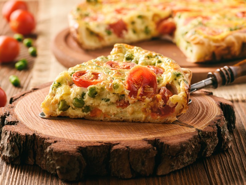 Vegetarische Quiche mit Erbsen und Tomaten.