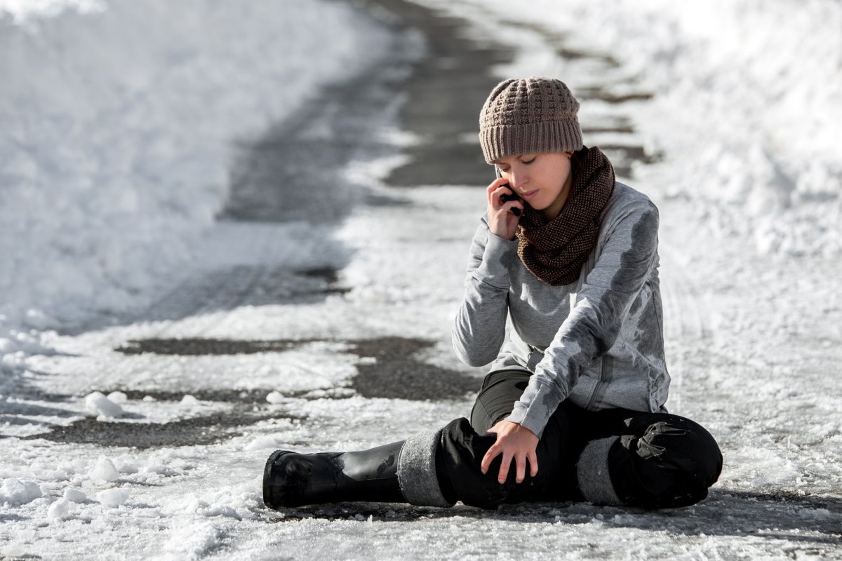 Frau, die bei Schnee und Glätte ausgerutscht ist