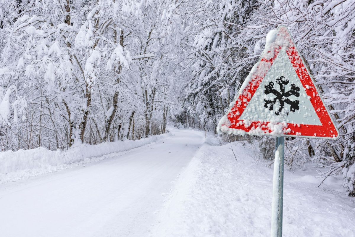 Eine schneebedeckte Landschaft mit einem Straßenschild