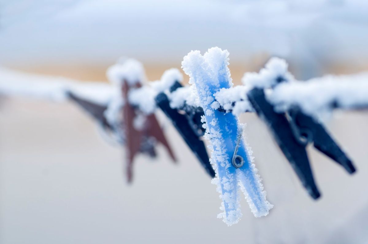 Schneebedeckte Wäscheklammern an der Leine